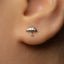 A close-up of a person's ear with a small silver earring featuring an umbrella design.