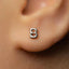 A close-up of a person's ear with a small silver earring featuring the number 8 on it.