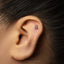 a close-up view of a person's ear with a small silver earring in the earlobe.