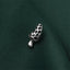 A silver mushroom-shaped pin is resting on a dark green fabric.
