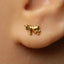 A close-up view of a person's ear adorned with a small gold-colored earring featuring a small animal design.