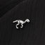 A small silver dinosaur figurine is resting on a black fabric surface.