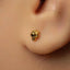 A close-up of a person's ear with a small gold earring featuring a lion's head design.