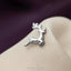 A silver metal deer-shaped pin is resting on a white fabric surface.