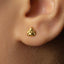 A close-up of a person's ear with a small gold earring in the earlobe.
