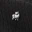 A small silver dog figurine is placed on a black fabric surface.