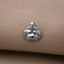 A small silver Buddha statue is displayed on a beige fabric surface.