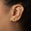 A close-up of a person's ear with a small gold earring in the earlobe.