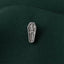 A silver pin with a skeleton design is shown against a dark green fabric background.