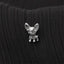A small silver dog-shaped pin is attached to a black fabric surface.