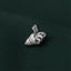A silver pin with a bird-like design is resting on a dark green fabric.