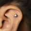 A silver earring in the shape of a skull is visible in the image.