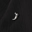 A silver metal object resembling a claw or talon is resting on a black fabric surface.