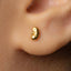 A close-up view of a person's ear with a small gold earring in the earlobe.