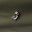 A close-up image of a small, colorful bird pin on a textured fabric background.