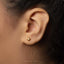 A close-up view of a person's ear adorned with a small gold star-shaped earring.