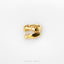 A gold-colored metal object resembling a dinosaur skull or jawbone is shown against a white background.