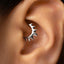 A close-up of a person's ear with a silver ring or earring in the earlobe.