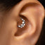 A close-up of a person's ear with a silver hoop earring in the earlobe.