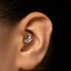 A close-up of a person's ear with a silver hoop earring in the earlobe.
