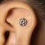 A silver star-shaped piercing in the ear.
