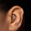 A close-up of a person's ear with a silver ring or earring in the earlobe.