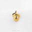 A small gold-colored charm in the shape of a smiling acorn.