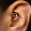 A close-up of a person's ear with a diamond-encrusted earring visible.