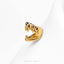 A close-up image of a gold-colored metal object, possibly a ring or earring, with an open mouth design.