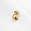 A small golden cat figurine is sitting on a white surface.