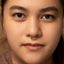 A close-up portrait of a young woman with a nose ring, looking directly at the camera with a neutral expression.