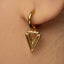 A close-up of a person's ear wearing a gold-colored earring with a triangular pendant.