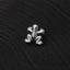 A small silver frog-shaped object is resting on a black fabric surface.