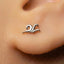 A close-up of a person's ear with a small silver earring in the earlobe.