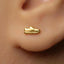 A gold earring with a small shoe-shaped charm is visible in the person's ear.