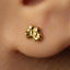 A close-up of a person's ear with a small gold earring in the earlobe.