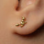 A close-up view of a person's ear adorned with a small gold earring featuring a small bird-like design.