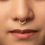 A close-up portrait of a woman with a nose piercing, looking directly at the camera.
