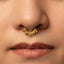 A close-up portrait of a woman with a gold nose ring, looking directly at the camera with a neutral expression.