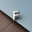 A close-up image of a shiny metal letter 'F' placed on a textured surface.