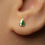 A close-up of a person's ear with a small, colorful earring in the earlobe.