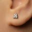 A close-up of a person's ear with a small, silver earring in the earlobe.