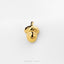 A small gold-colored charm in the shape of a smiling acorn.