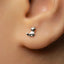 A small silver earring in the shape of a cat is visible in the person's ear.