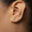A small silver earring in the shape of a cat is visible in the person's ear.