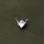 A silver origami crane is displayed on a textured green surface.