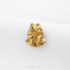 A small golden figurine of a dog sitting on its hind legs is displayed against a white background.