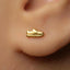 A gold earring with a small shoe-shaped charm is visible in the person's ear.