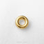 A single, shiny gold-colored ring is centered on a white textured background.