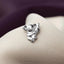 A small silver charm in the shape of a koala bear is displayed on a fabric surface.